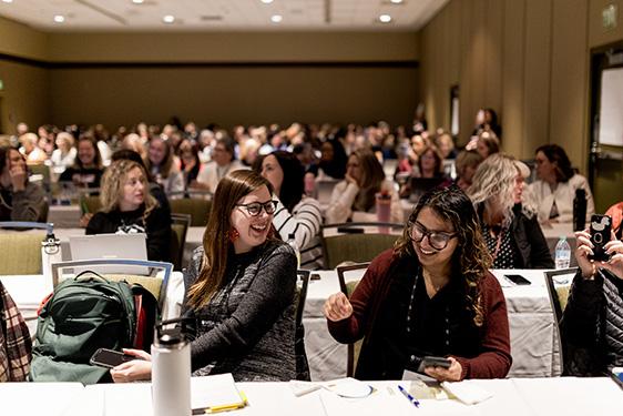 Two conference session attendees laugh together